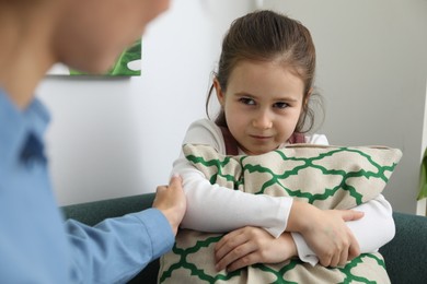 Photo of Psychologist having therapy session with stubborn girl indoors