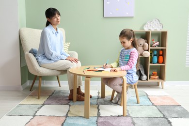 Photo of Little girl drawing during psychological evaluation in office