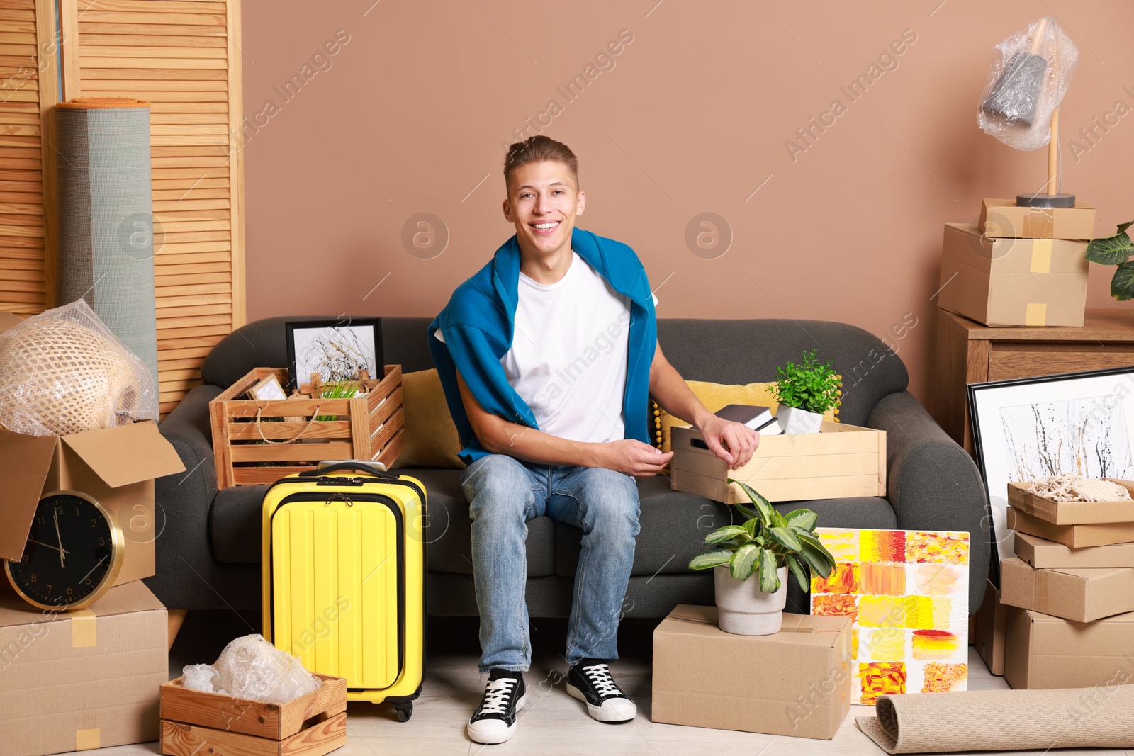 Photo of Happy man with different stuff in new apartment. Housewarming party