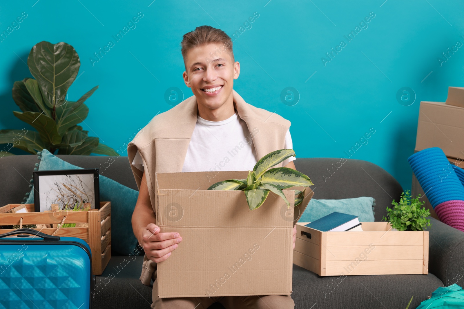 Photo of Happy man with different stuff in new apartment. Housewarming party