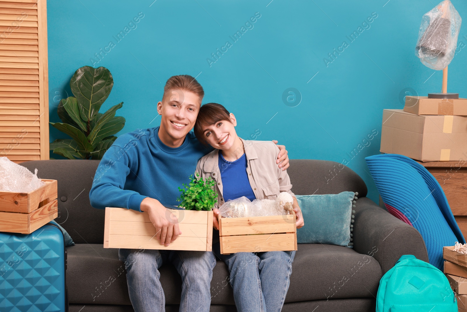 Photo of Happy couple with different stuff in new apartment. Housewarming party