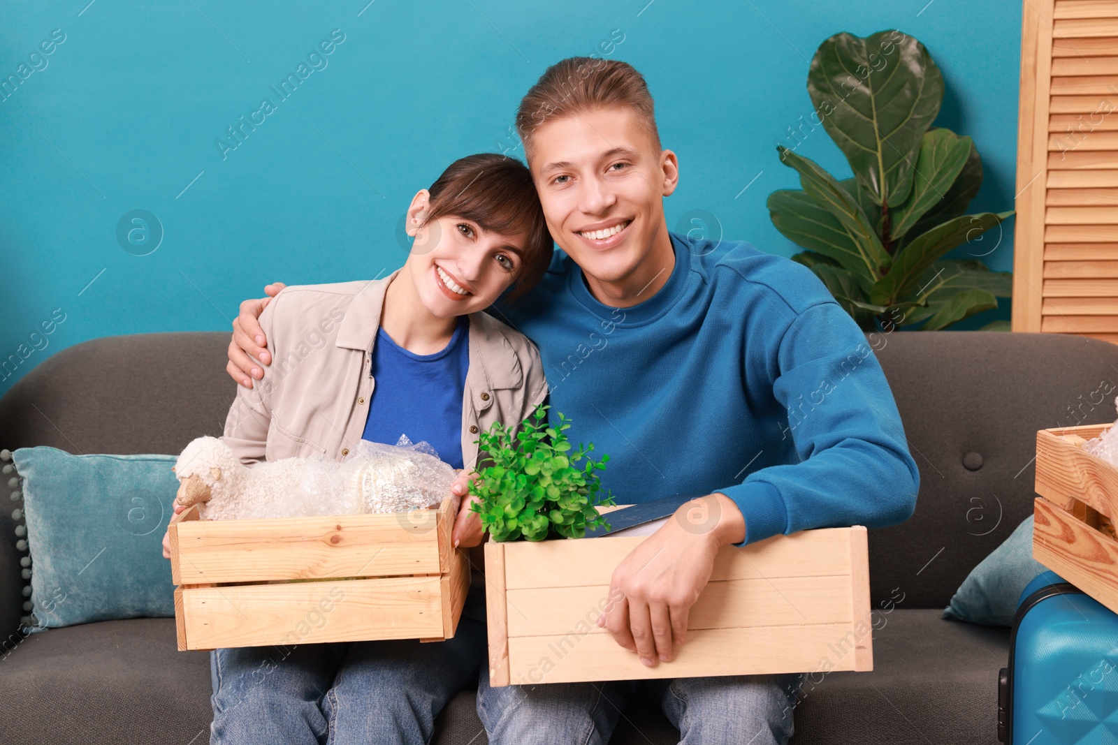 Photo of Happy couple with different stuff in new apartment. Housewarming party