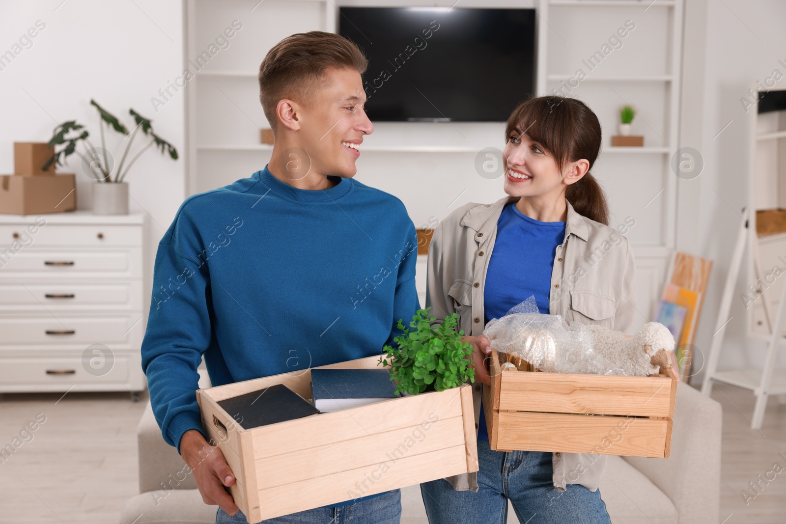 Photo of Happy couple with different stuff in new apartment. Housewarming party