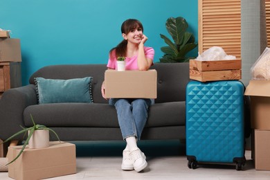 Photo of Happy woman with different stuff in new apartment. Housewarming party