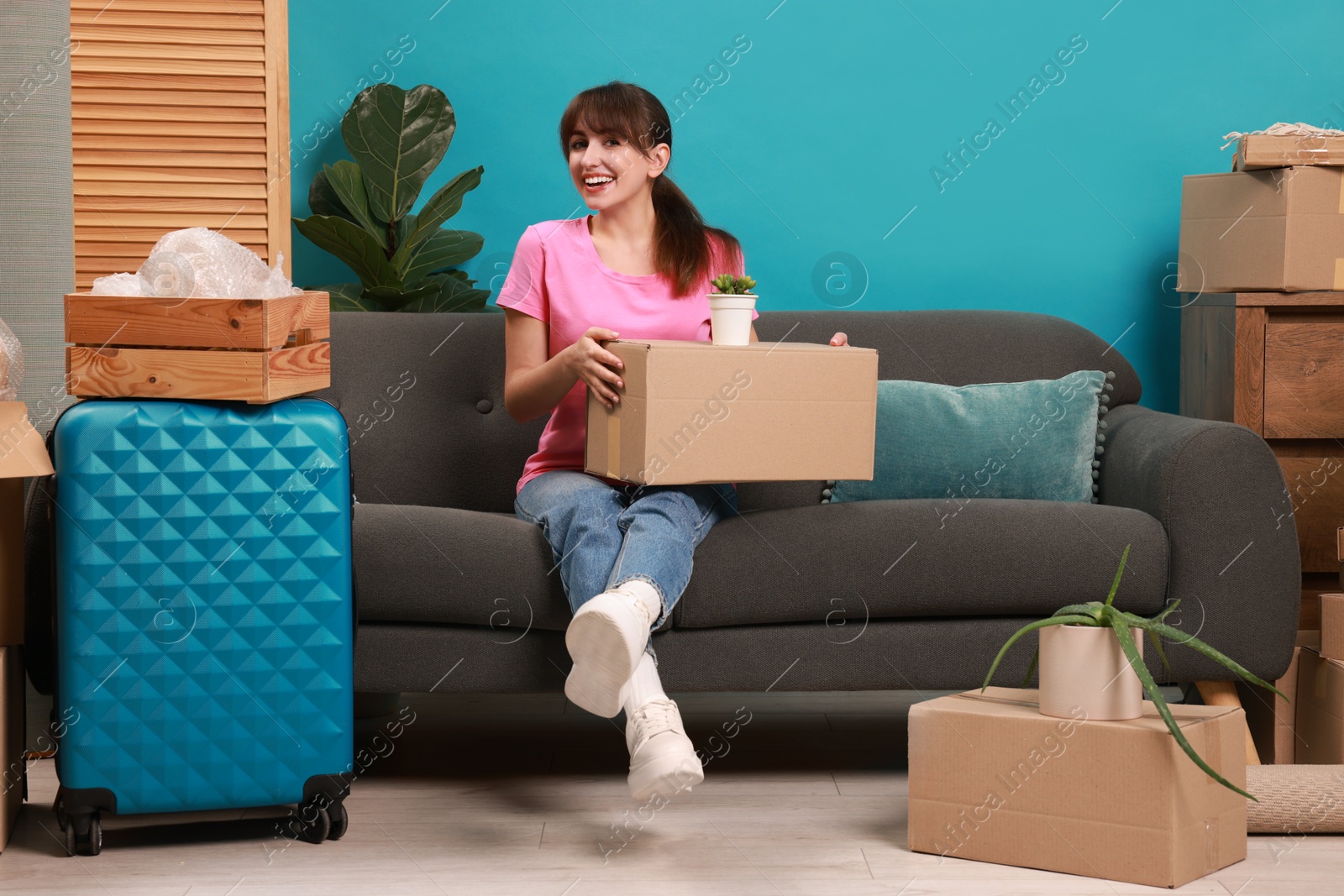 Photo of Happy woman with different stuff in new apartment. Housewarming party