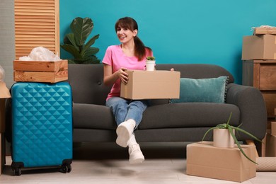 Photo of Happy woman with different stuff in new apartment. Housewarming party