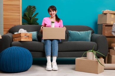 Happy woman with moving boxes in new apartment. Housewarming party