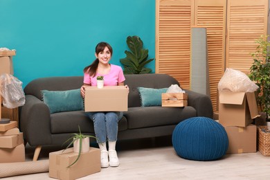 Happy woman with moving boxes in new apartment. Housewarming party