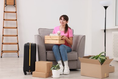 Photo of Happy woman with different stuff in new apartment. Housewarming party