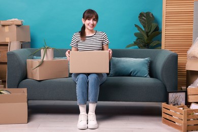 Happy woman with moving boxes in new apartment. Housewarming party