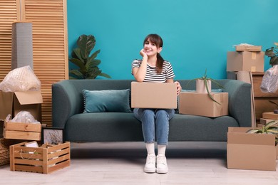 Photo of Happy woman with moving boxes in new apartment. Housewarming party