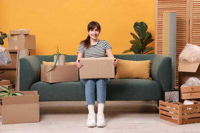 Happy woman with moving boxes in new apartment. Housewarming party