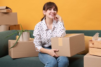 Happy woman with moving boxes in new apartment. Housewarming party