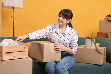 Happy woman with moving boxes in new apartment. Housewarming party