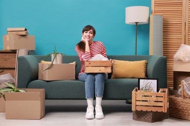 Photo of Happy woman with moving boxes in new apartment. Housewarming party