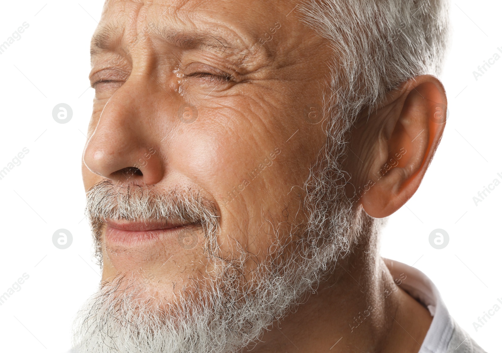 Photo of Sad senior man crying on white background, closeup