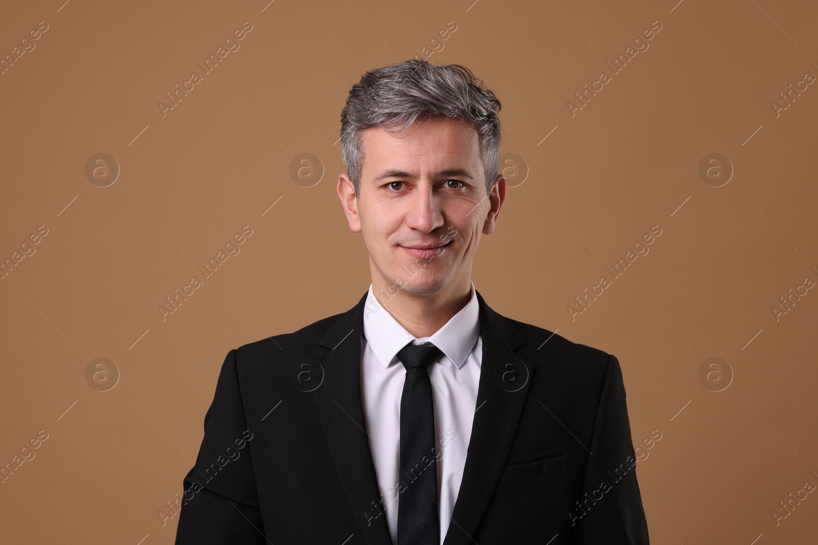 Photo of Portrait of businessman in jacket on brown background