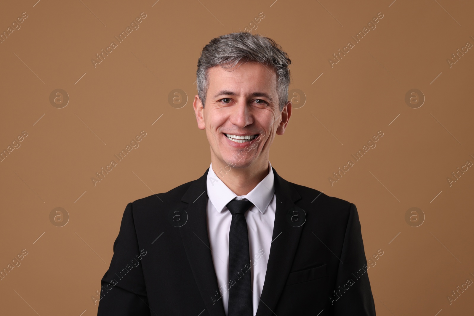 Photo of Portrait of businessman in jacket on brown background