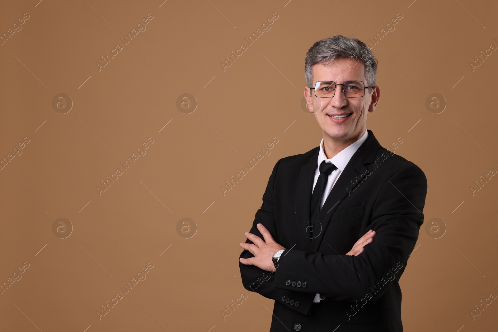 Photo of Portrait of businessman in glasses on brown background, space for text