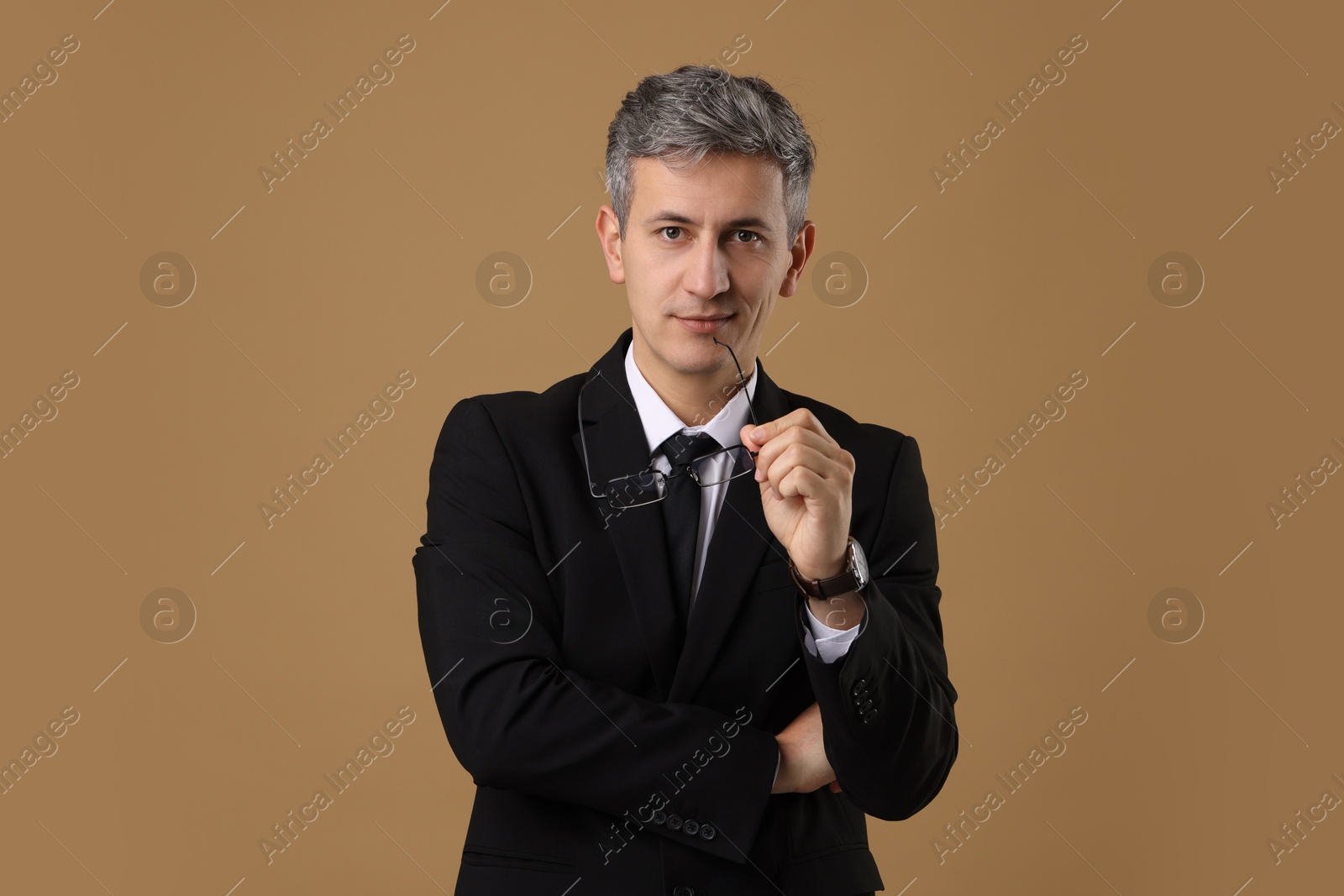 Photo of Portrait of businessman with glasses on brown background