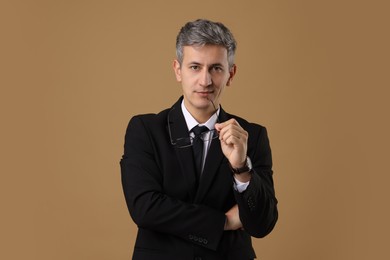 Photo of Portrait of businessman with glasses on brown background