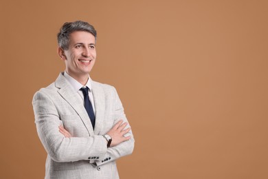 Photo of Portrait of businessman in jacket on brown background, space for text