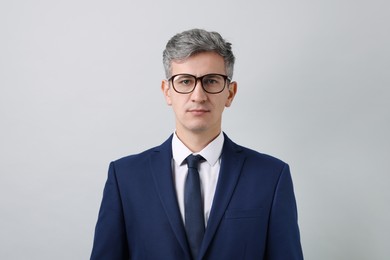 Photo of Portrait of businessman in glasses on light grey background