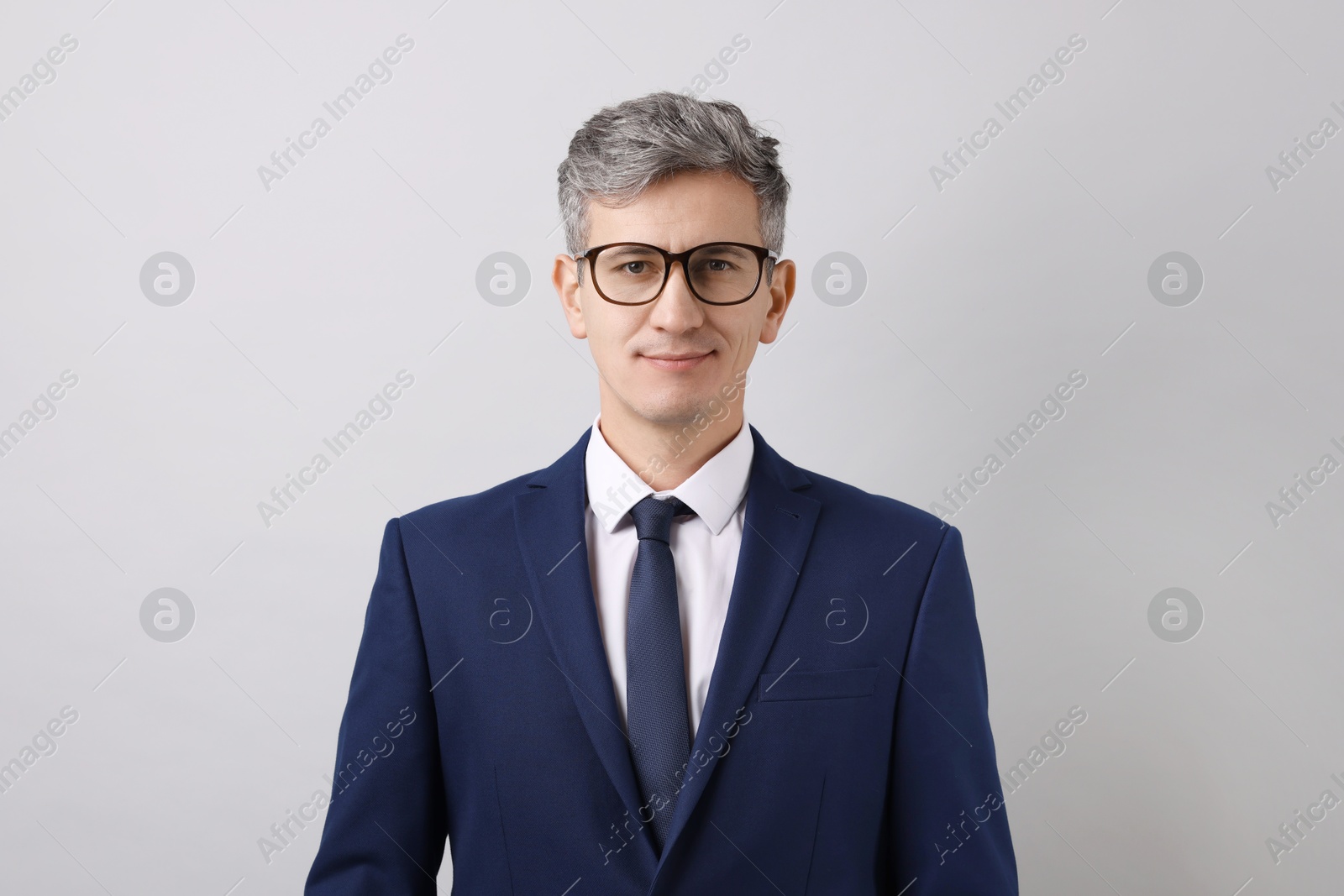 Photo of Portrait of businessman in glasses on light grey background