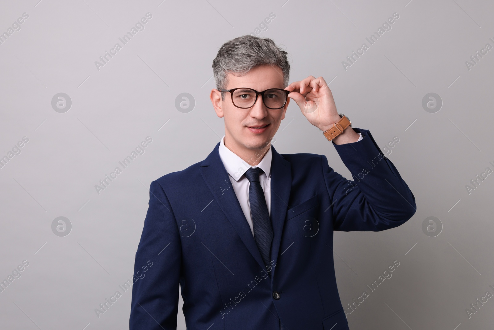 Photo of Portrait of businessman in glasses on light grey background