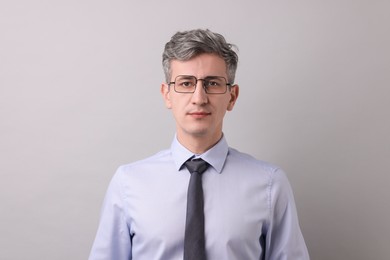 Photo of Portrait of businessman in glasses on light grey background