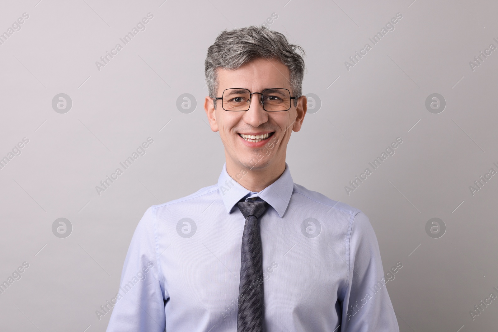 Photo of Portrait of businessman in glasses on light grey background