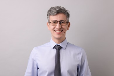 Photo of Portrait of businessman in glasses on light grey background