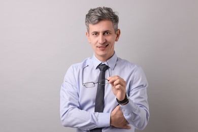 Photo of Portrait of businessman with glasses on light grey background