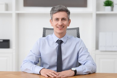 Photo of Portrait of businessman at table in office