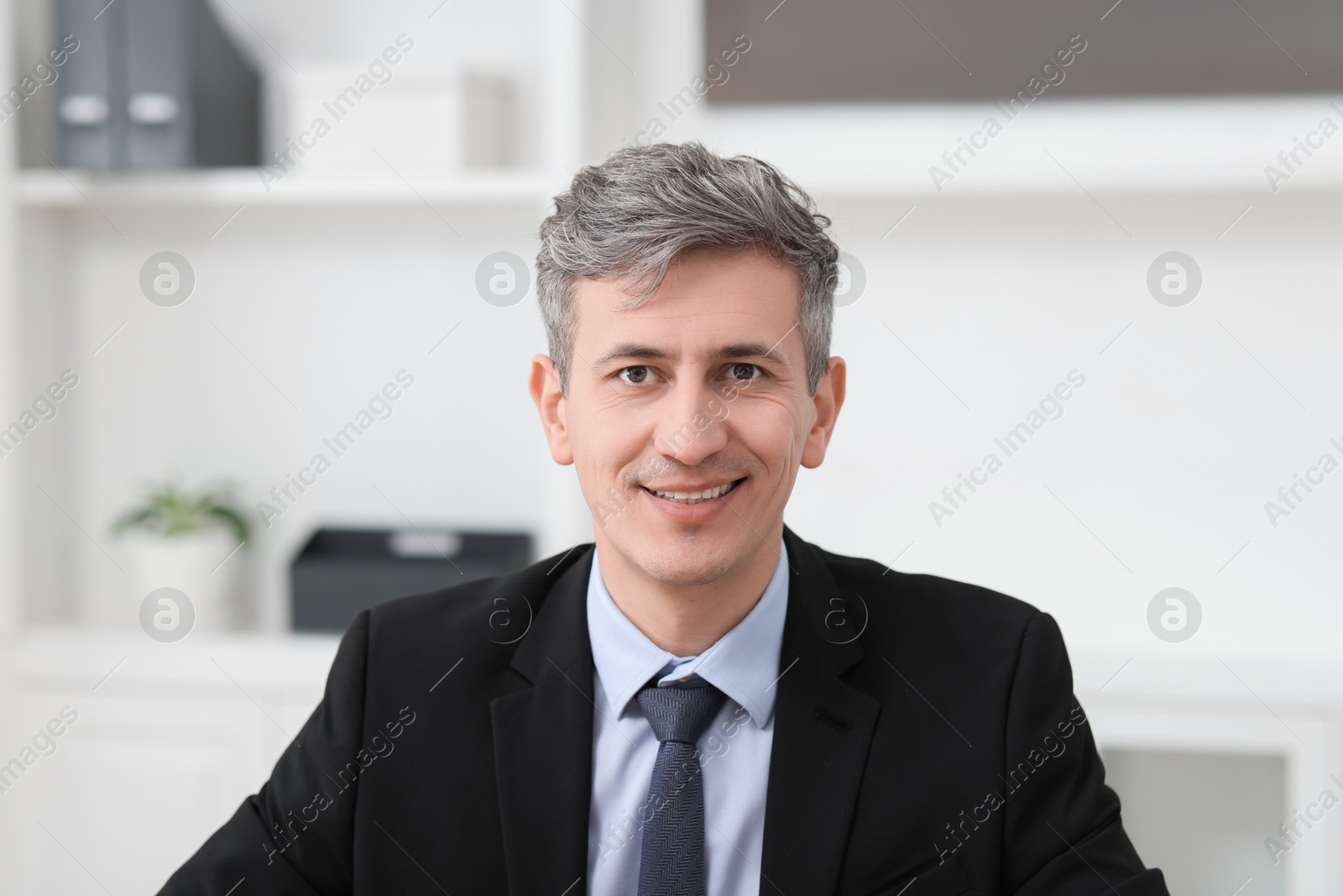 Photo of Portrait of businessman in jacket at workplace