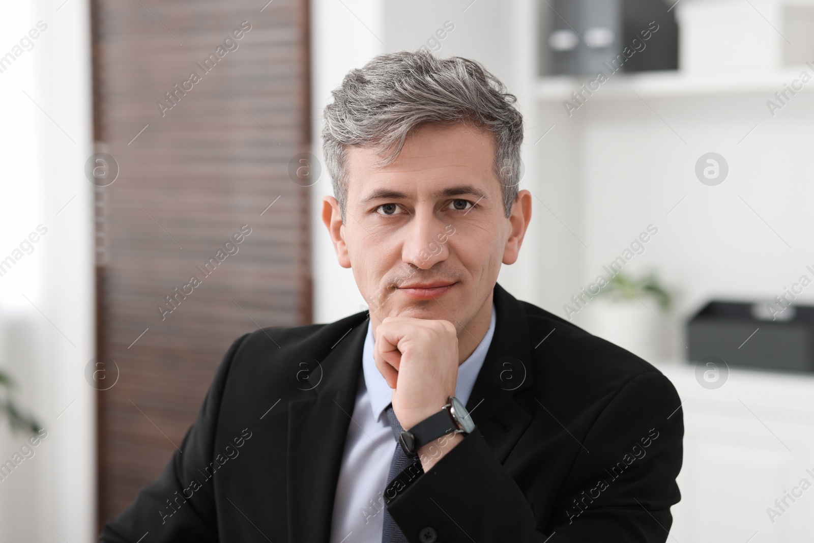 Photo of Portrait of businessman in jacket at workplace