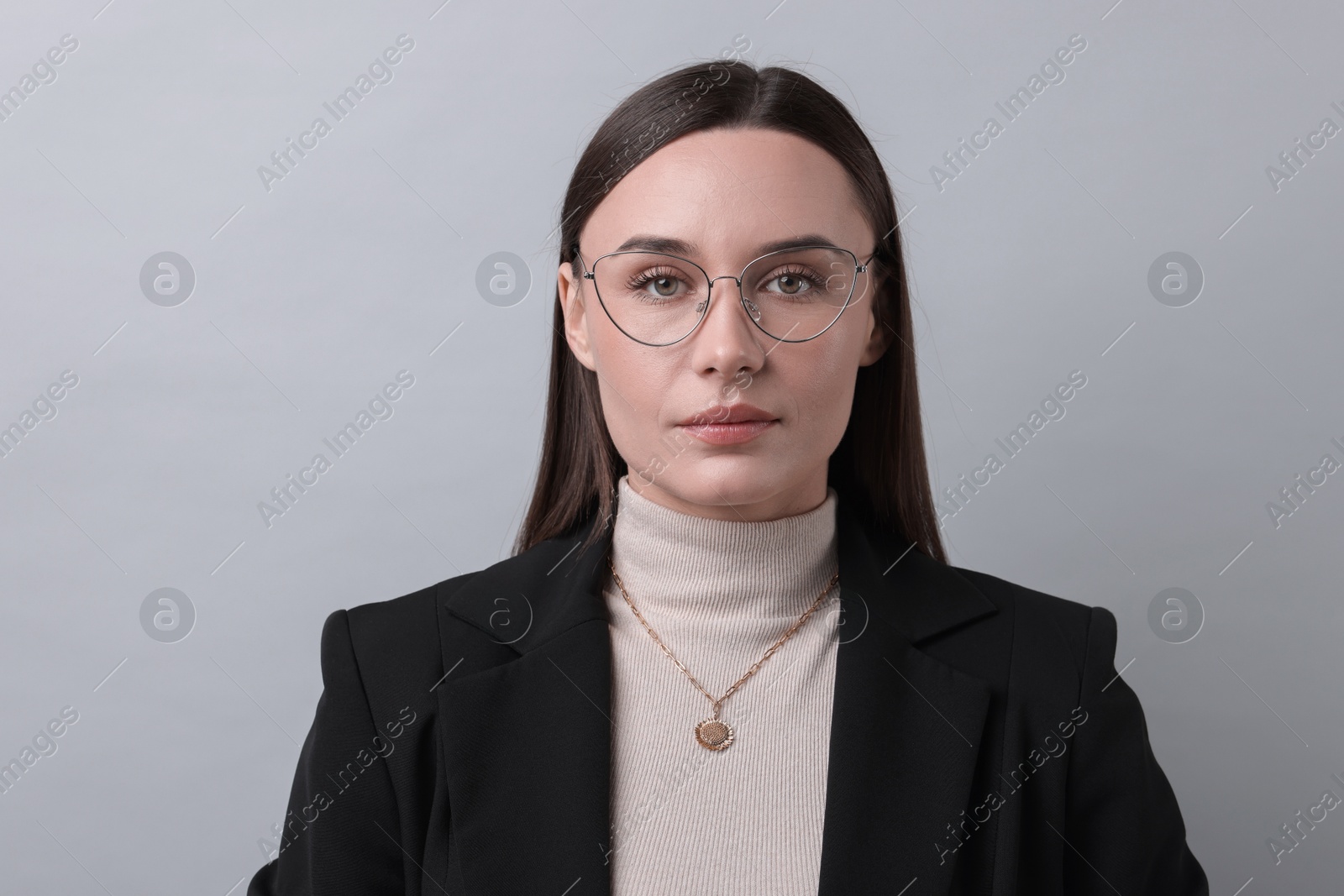 Photo of Portrait of businesswoman in glasses on light grey background