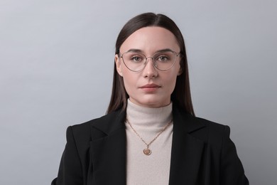 Photo of Portrait of businesswoman in glasses on light grey background