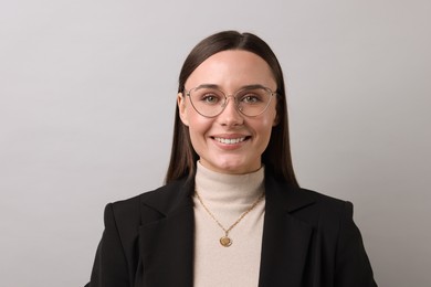 Photo of Portrait of businesswoman in glasses on light grey background