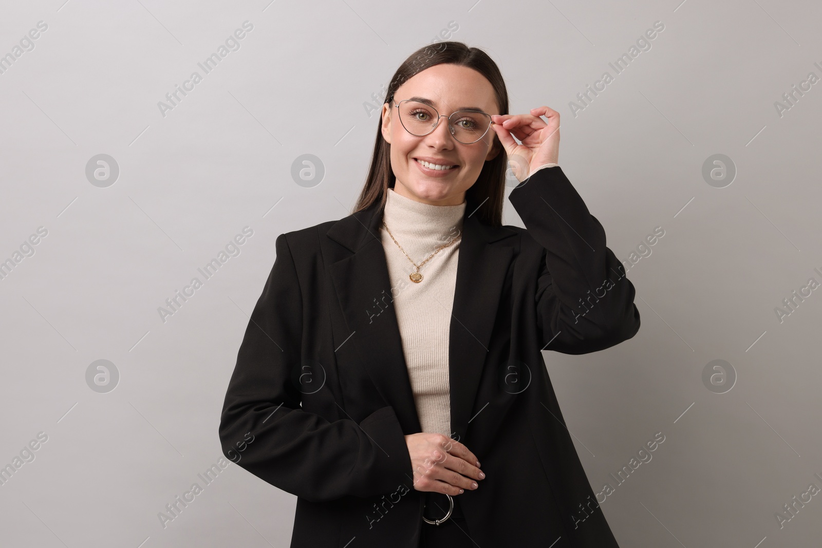 Photo of Portrait of businesswoman in glasses on light grey background