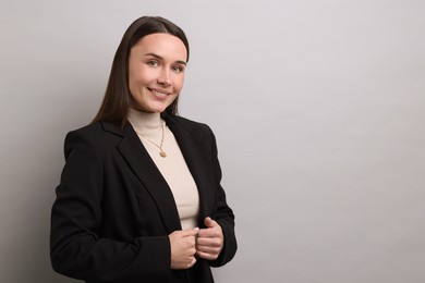 Portrait of businesswoman on light grey background, space for text