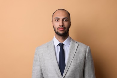 Photo of Portrait of businessman in jacket on beige background