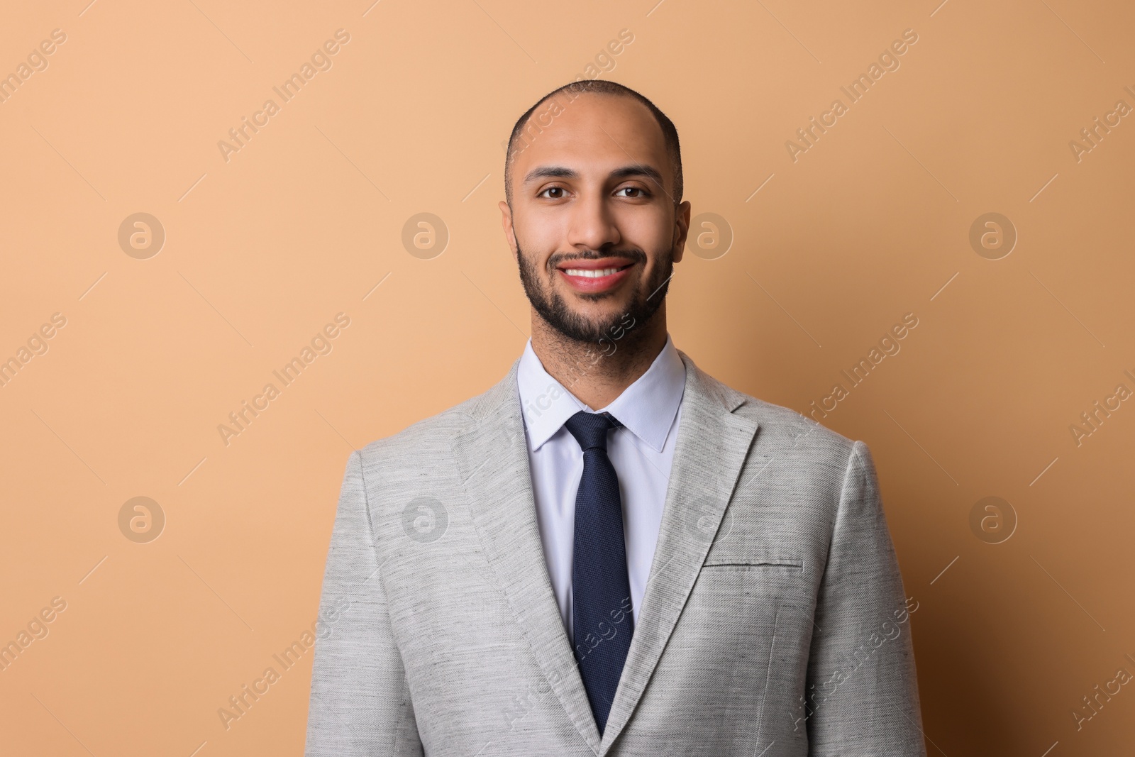 Photo of Portrait of businessman in jacket on beige background