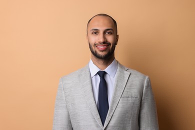 Portrait of businessman in jacket on beige background