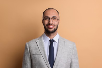 Portrait of businessman in glasses on beige background