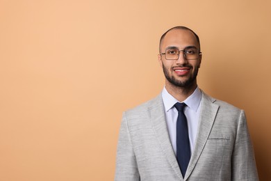 Photo of Portrait of businessman in glasses on beige background, space for text