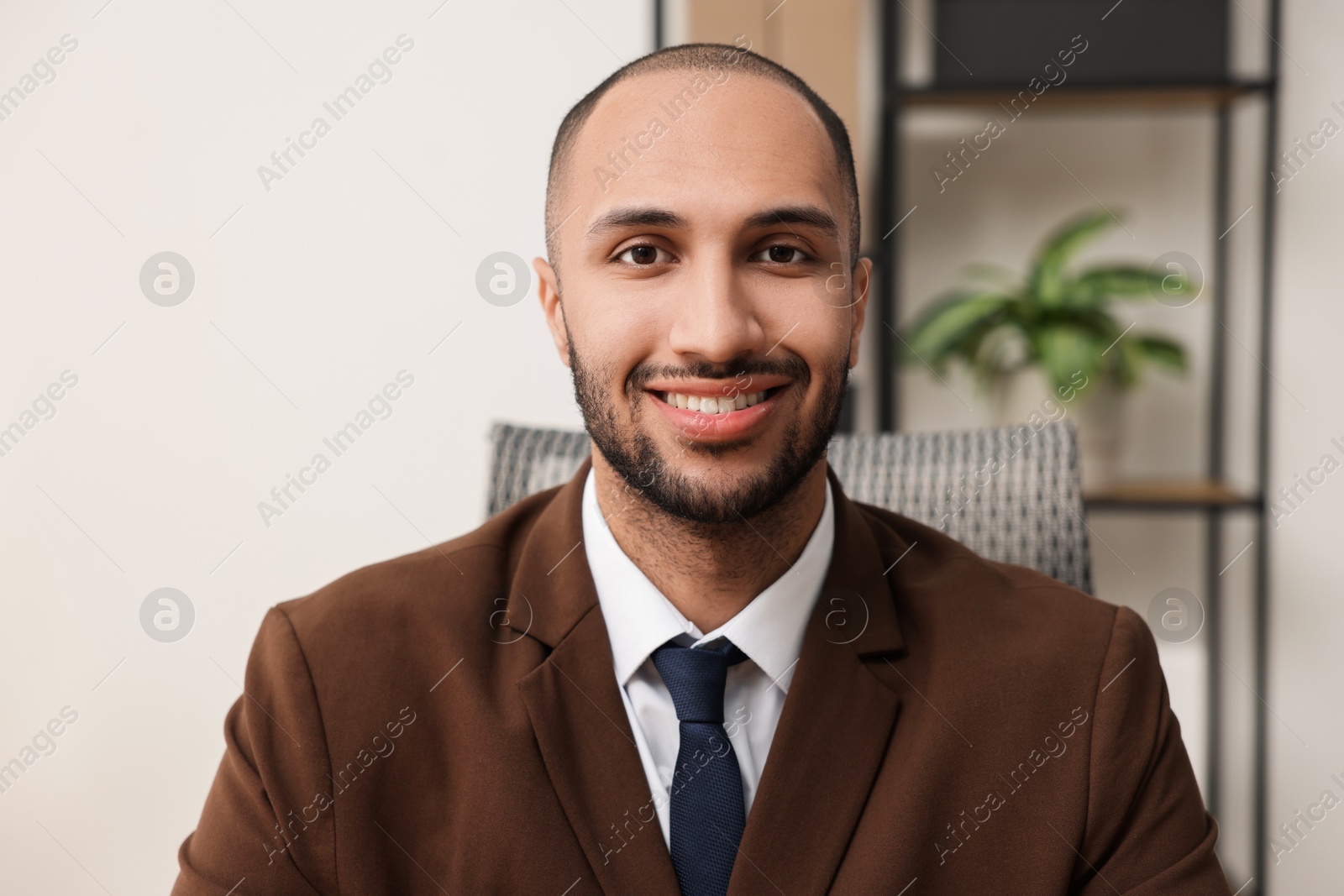 Photo of Portrait of happy businessman in jacket indoors