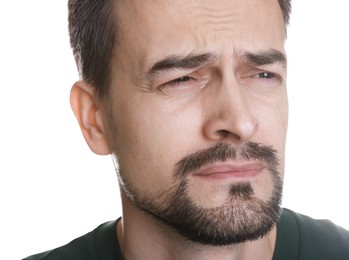 Sad man crying on white background, closeup