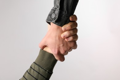 Help and support. People holding hand on light grey background, closeup