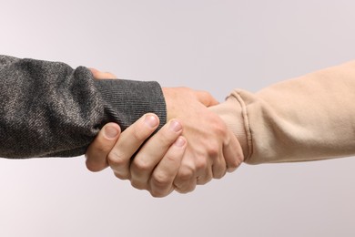 Photo of Help and support. People holding hand on light grey background, closeup